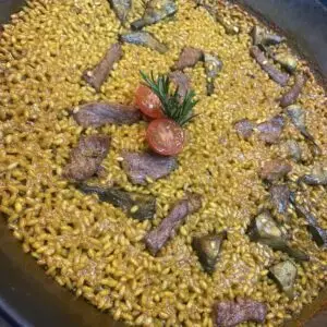 Arroz con secreto ibérico, alcachofa  y triguero
